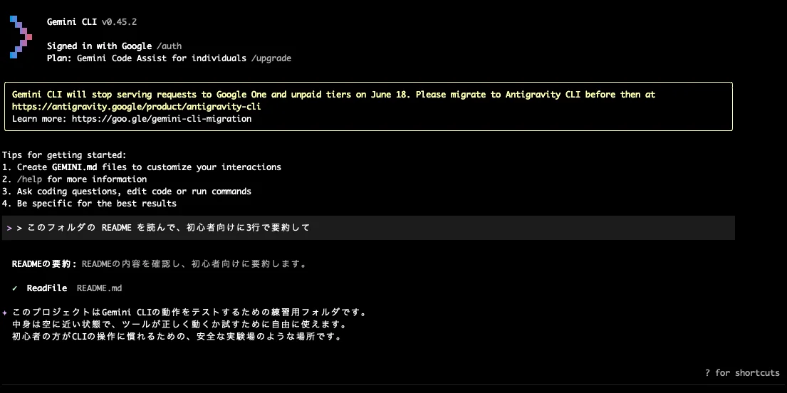 Gemini CLI v0.45.2 を起動し、README を3行で要約するよう日本語で依頼したところ、ReadFile で README.md を読み込んだうえで初心者向けの要約を返している実際のセッション画面。画面上部には 6 月 18 日の Antigravity CLI 移行通知も表示されている